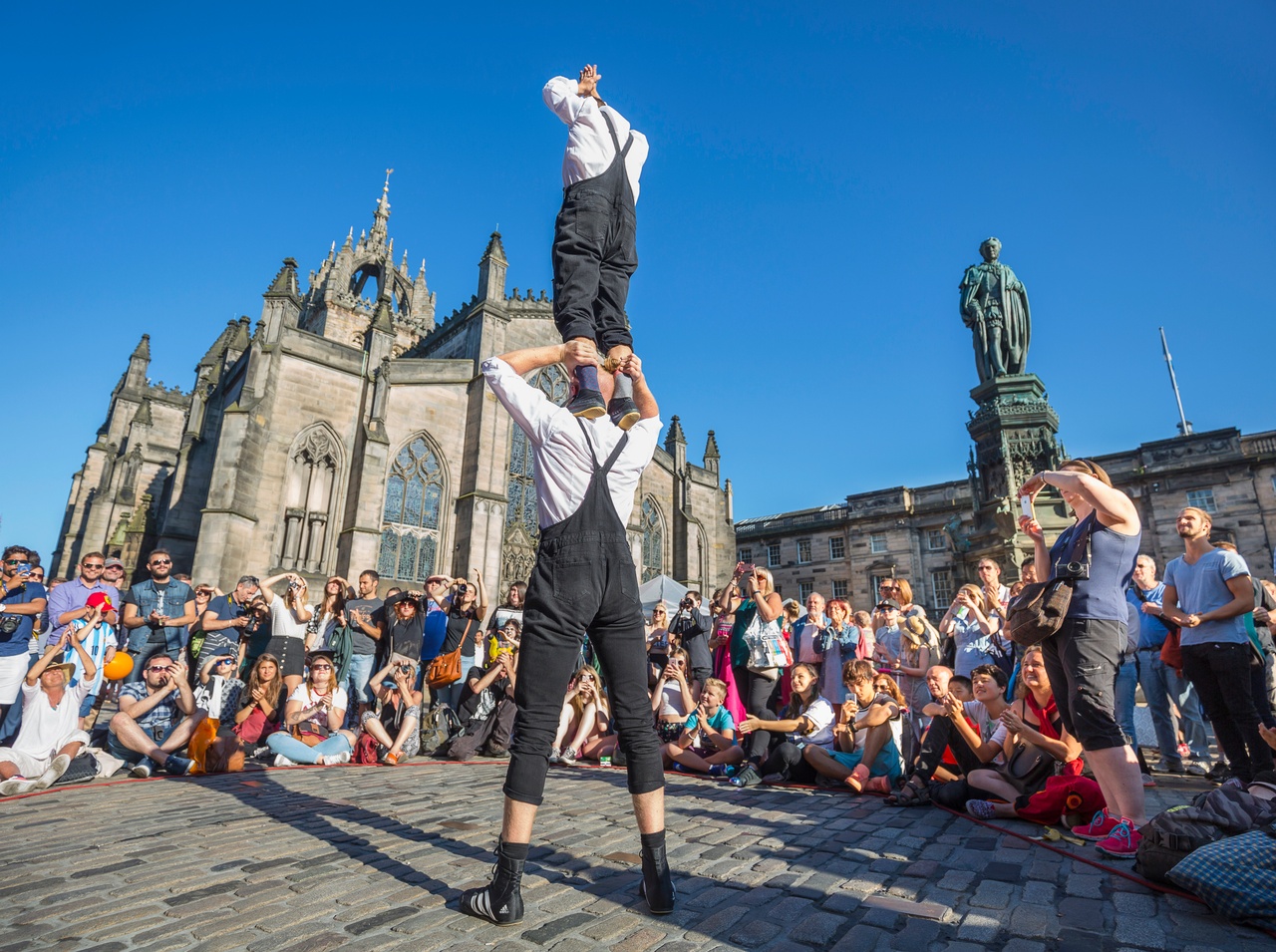 The City Apartments Edinburgh 4 Street performers entertaining a crowd on the Royal Mile near St Giles Cathedral, Edinburgh