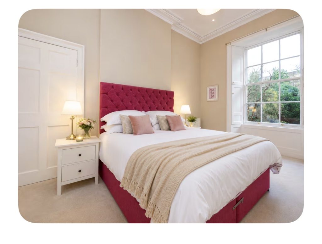 New Town Apartment 7 Bedroom with pink upholstered headboard and bedside table at The City Apartments Edinburgh